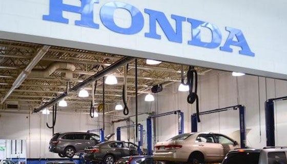 Honda service center exterior, featuring a sign and service bays for vehicle maintenance and repairs.